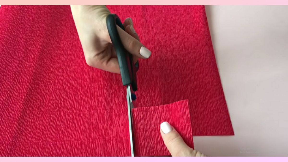 Cắt giấy nhún màu đỏ thành hình vuông 6cm để làm cánh hoa