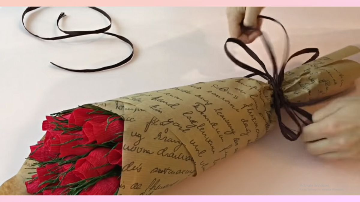 Dùng băng keo cố định hoa và bọc giấy bó hoa, thắt ruy băng hoàn thiện