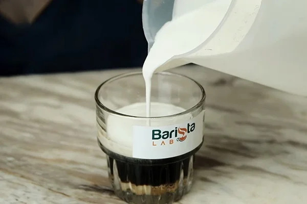 Rót từ từ lớp kem mặn đã đánh bông vào ly cà phê