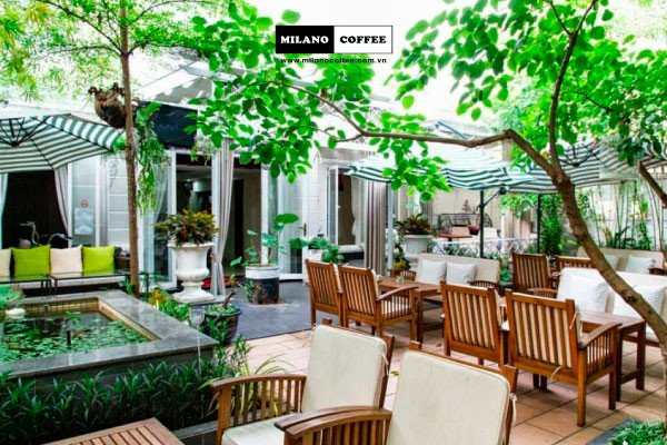 Một quán cà phê sân vườn với nhiều cây xanh được bố trí hài hòa