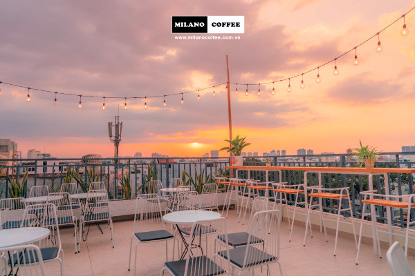 Mô hình cà phê sân vườn nhỏ trên sân thượng với cây xanh và view thành phố