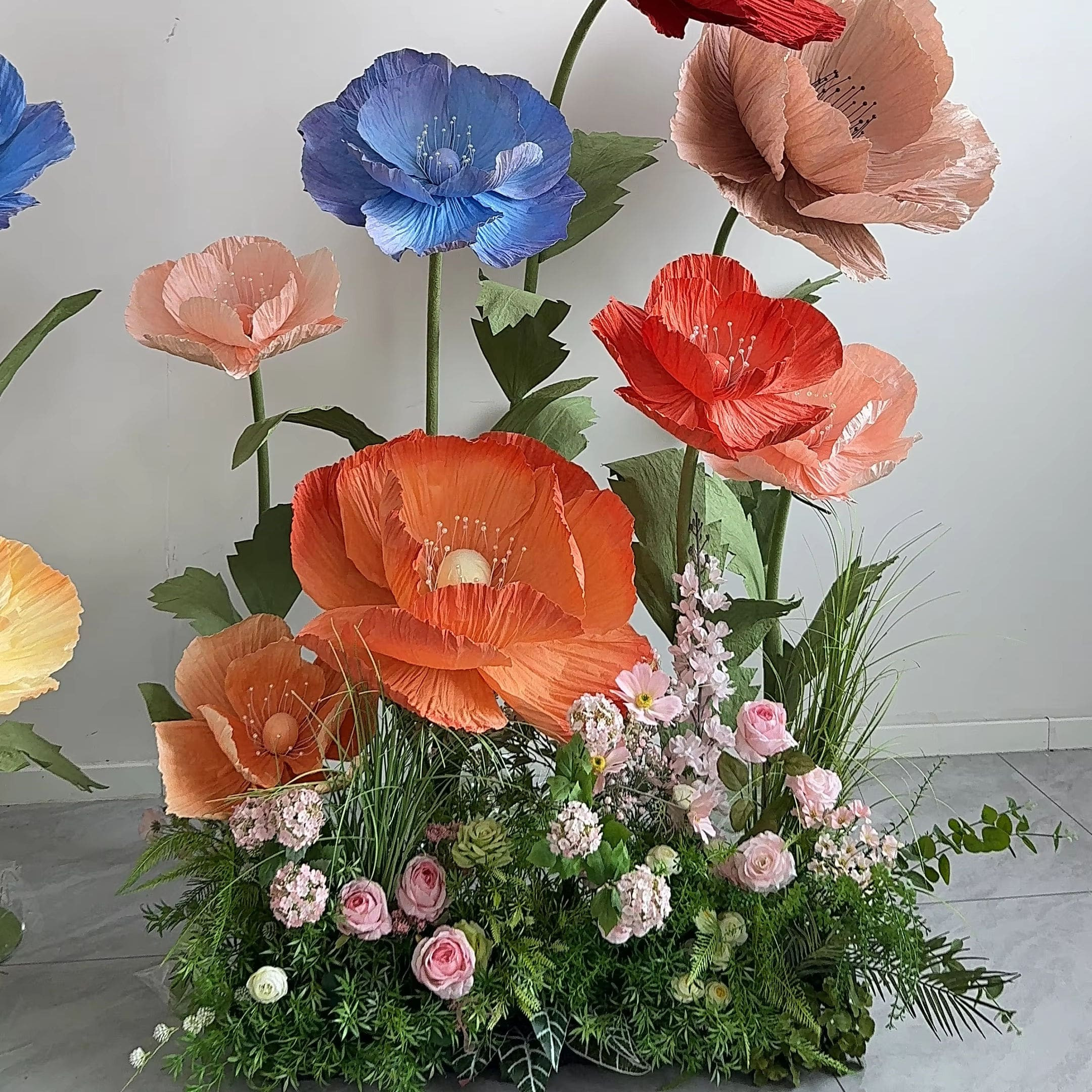 Khóm hoa khổng lồ nhiều màu sắc được tạo từ giấy nhún XH57, đang được sử dụng để trang trí một không gian nội thất rộng rãi, thể hiện tính ứng dụng đa dạng của sản phẩm