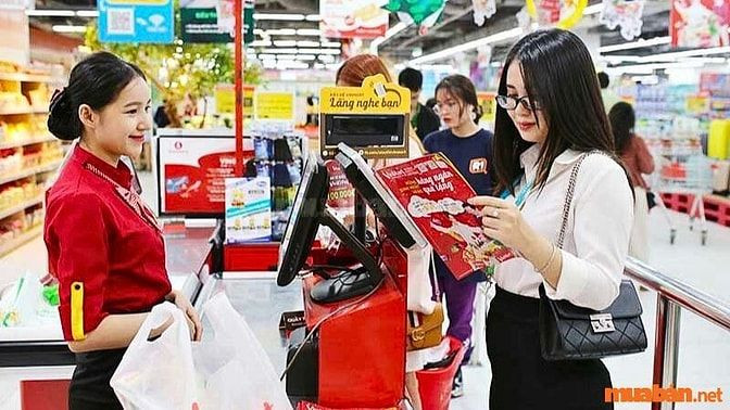Nhân viên thu ngân xử lý giao dịch thanh toán cho khách hàng tại quầy