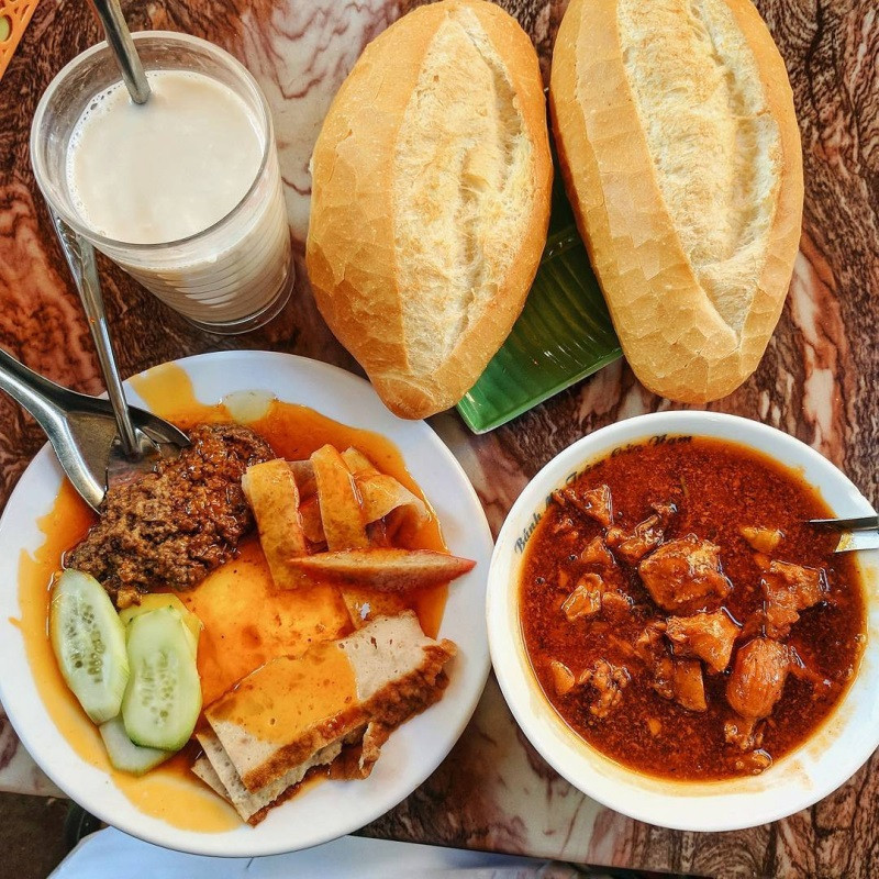 Ổ bánh mì giòn rụm chấm cùng bát sốt vang nóng hổi, thịt bò mềm