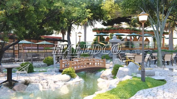 Cổng quán cafe sân vườn được trang trí với cây xanh và ánh sáng ấm cúng