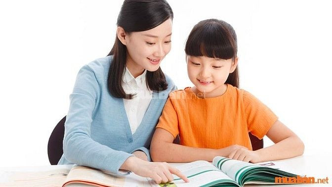 Gia sư đang hướng dẫn học sinh làm bài tập vào buổi tối