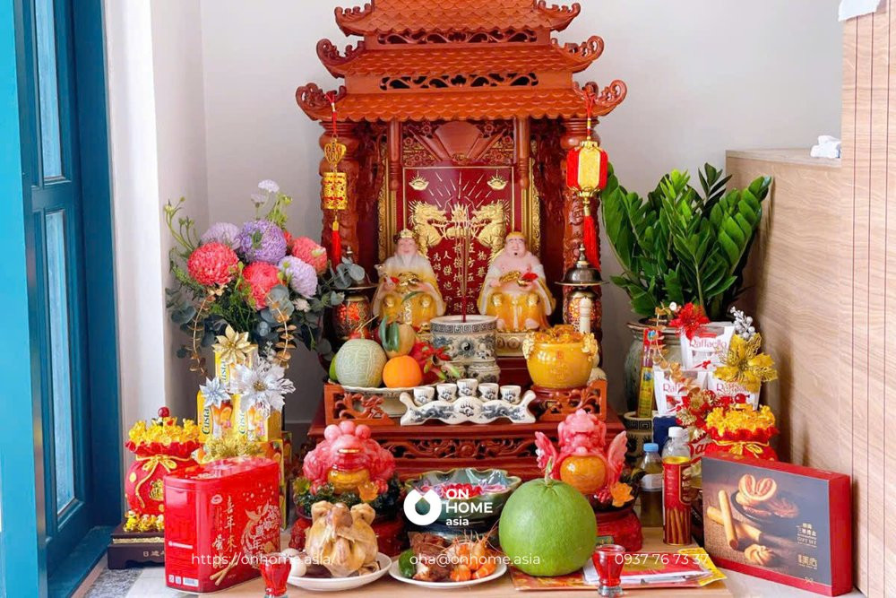 Bàn thờ Thần Tài được bài trí đầy đủ vật phẩm cúng như tượng, bát hương, hoa và mâm ngũ quả