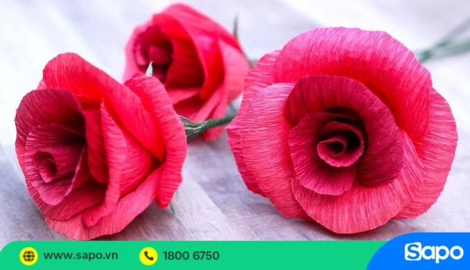 Hoa hồng màu hồng được làm thủ công từ giấy nhún, thể hiện sự tinh xảo và bền đẹp
